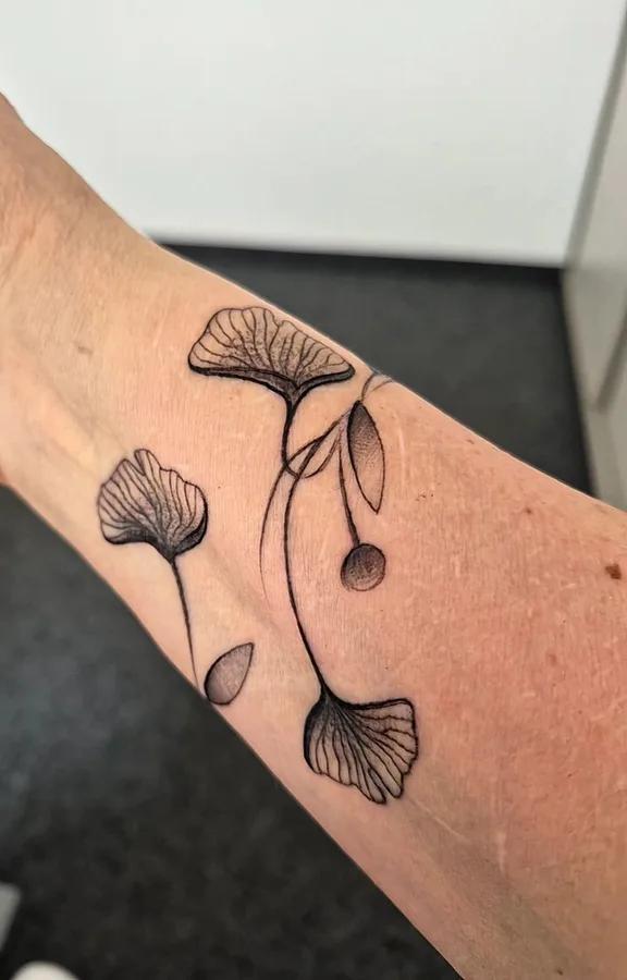 Fine-Line-Tattoo mit Ginkgo-Blättern am Unterarm, SkinLove Marchtrenk