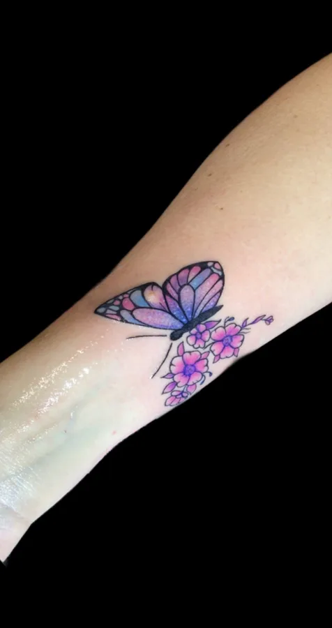 Farbiges Schmetterling-Tattoo mit Blueten am Unterarm, SkinLove Marchtrenk